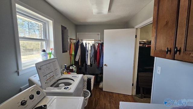 washroom with dark wood finished floors, washing machine and clothes dryer, cabinet space, a textured ceiling, and electric panel