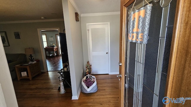 hallway featuring crown molding, a textured ceiling, baseboards, and wood finished floors