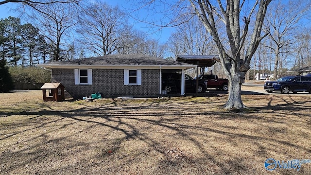 exterior space with a carport, brick siding, and driveway