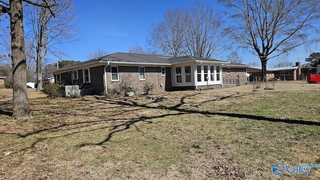 view of side of property featuring brick siding and a lawn