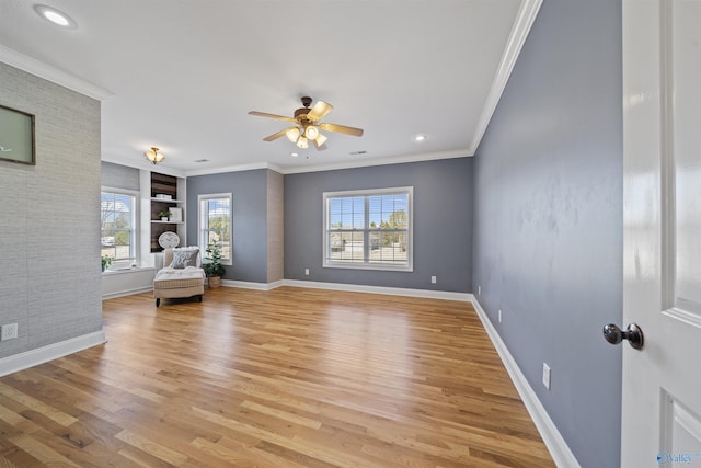 unfurnished living room featuring a healthy amount of sunlight, built in features, crown molding, and light wood-type flooring