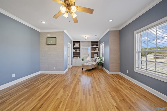 unfurnished room with ceiling fan, built in shelves, ornamental molding, and light hardwood / wood-style floors