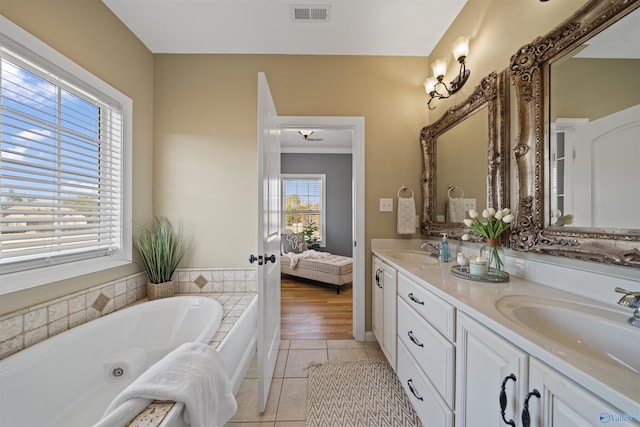 bathroom featuring vanity, tile patterned floors, and a washtub