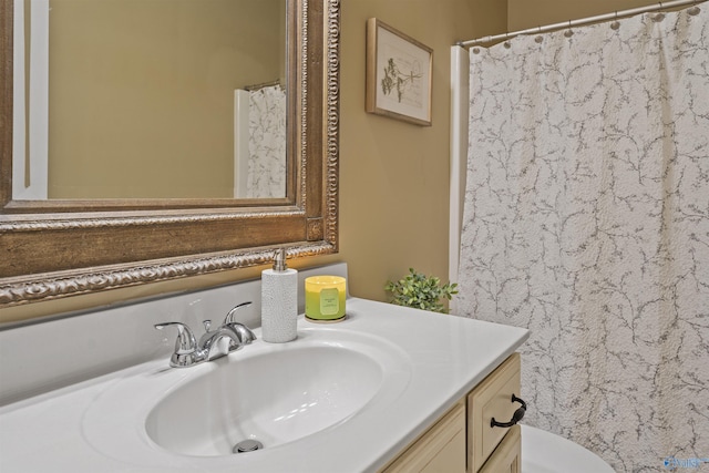 bathroom featuring toilet, vanity, and a shower with shower curtain