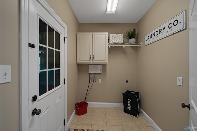 laundry room with cabinets, hookup for an electric dryer, and light tile patterned flooring