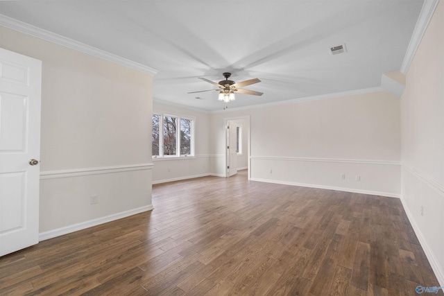 empty room with visible vents, crown molding, wood finished floors, and ceiling fan