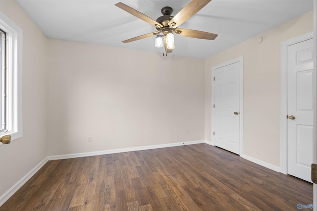 unfurnished room featuring dark wood-type flooring, ceiling fan, and baseboards