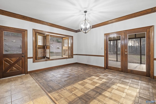 interior space with baseboards, ornamental molding, french doors, and a chandelier