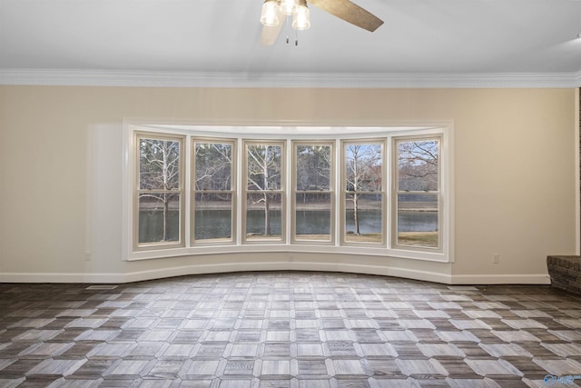 spare room featuring baseboards, ornamental molding, and a ceiling fan
