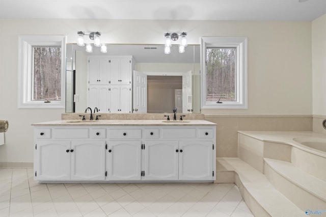 bathroom featuring double vanity, a sink, tile patterned floors, and visible vents
