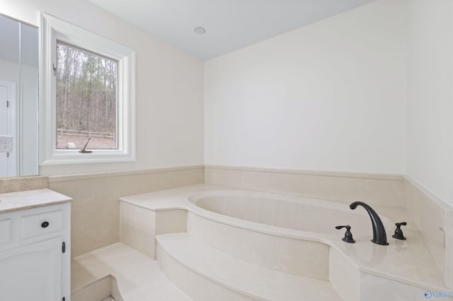 bathroom with vanity and a garden tub