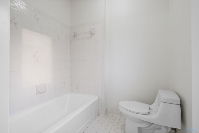 full bathroom featuring baseboards, toilet, and tile patterned flooring