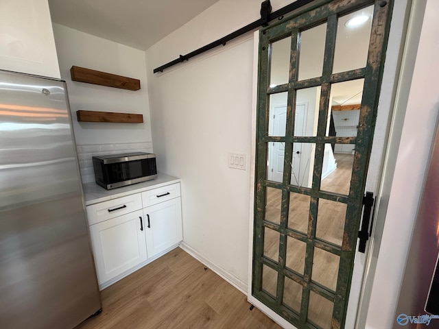 interior space featuring a barn door and light hardwood / wood-style flooring