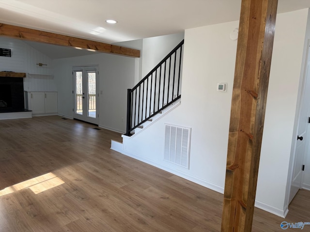 entrance foyer with lofted ceiling with beams, french doors, and hardwood / wood-style floors