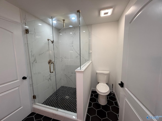 bathroom featuring tile patterned floors, toilet, and a shower with door