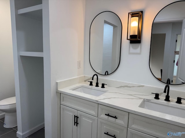 bathroom with tile patterned flooring, vanity, and toilet