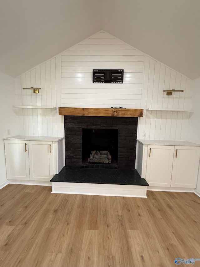 unfurnished living room featuring light hardwood / wood-style floors and lofted ceiling