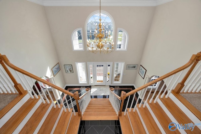 entrance foyer with a notable chandelier, a towering ceiling, hardwood / wood-style flooring, and a wealth of natural light