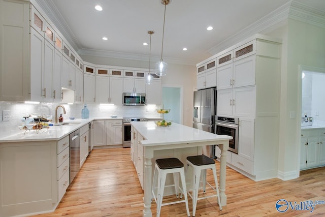 kitchen with a sink, a breakfast bar area, a center island, stainless steel appliances, and backsplash