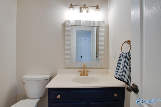 half bathroom featuring vanity and toilet
