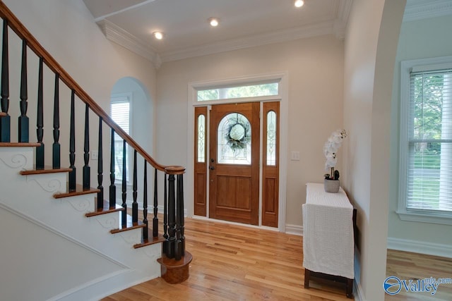 entrance foyer with crown molding, plenty of natural light, and light wood-style flooring