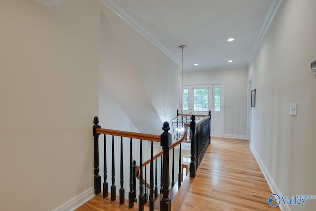 corridor with crown molding, baseboards, an upstairs landing, recessed lighting, and light wood-style flooring
