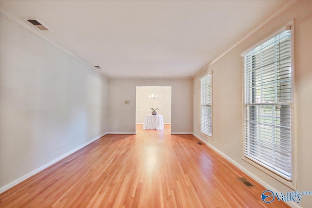 210 Spring Valley Ct SW, Huntsville, AL 35802 - unfurnished room with light wood-style flooring, crown molding, healthy amount of natural light, and a chandelier