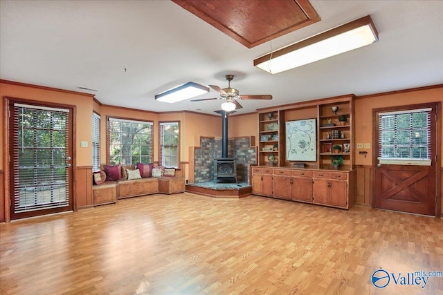 210 Spring Valley Ct SW, Huntsville, AL 35802 - living area with a wood stove, light wood-style flooring, attic access, ornamental molding, and a wainscoted wall