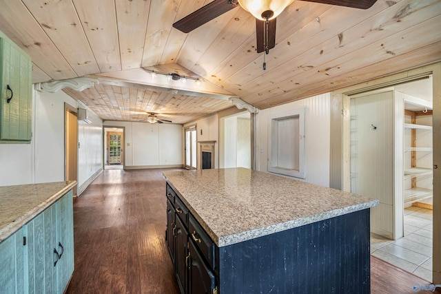 kitchen featuring a center island, dark wood-type flooring, vaulted ceiling, ceiling fan, and wood ceiling