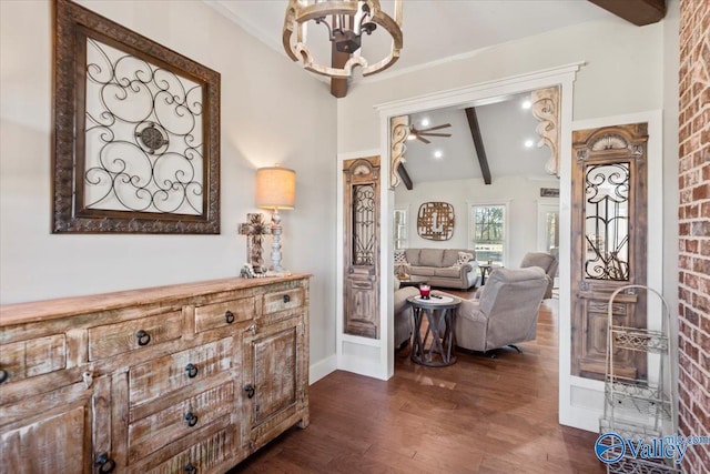 interior space featuring dark wood-style floors, lofted ceiling with beams, and baseboards