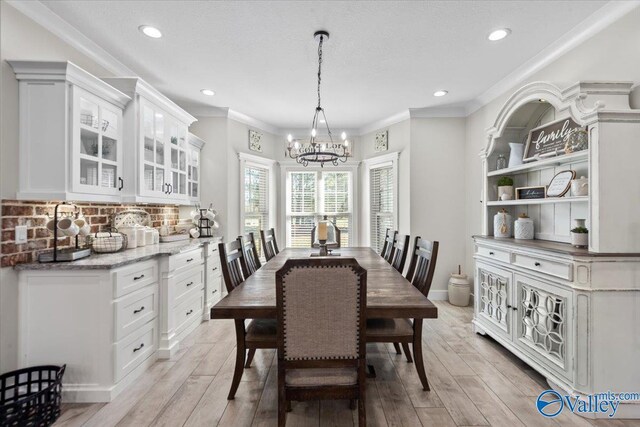 dining space featuring recessed lighting, a notable chandelier, crown molding, and light wood finished floors