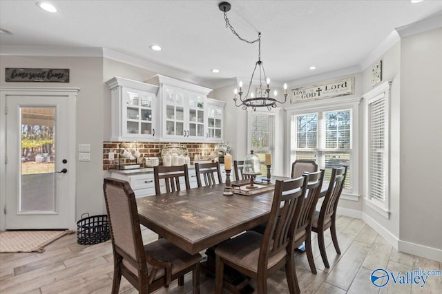 dining space with crown molding, light wood finished floors, recessed lighting, a chandelier, and baseboards