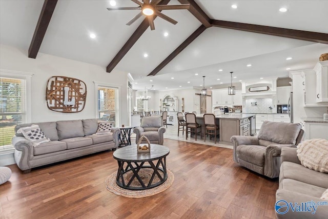 living room with beamed ceiling, plenty of natural light, and dark wood finished floors