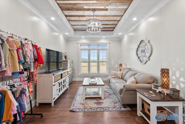 living area with a chandelier, ornamental molding, a raised ceiling, and dark wood finished floors