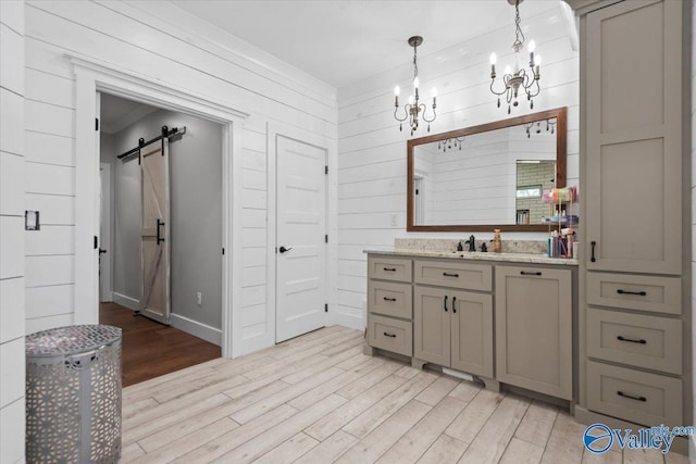 bathroom featuring an inviting chandelier, wood finished floors, vanity, and wooden walls