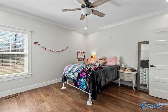 bedroom with crown molding, visible vents, dark wood finished floors, and baseboards