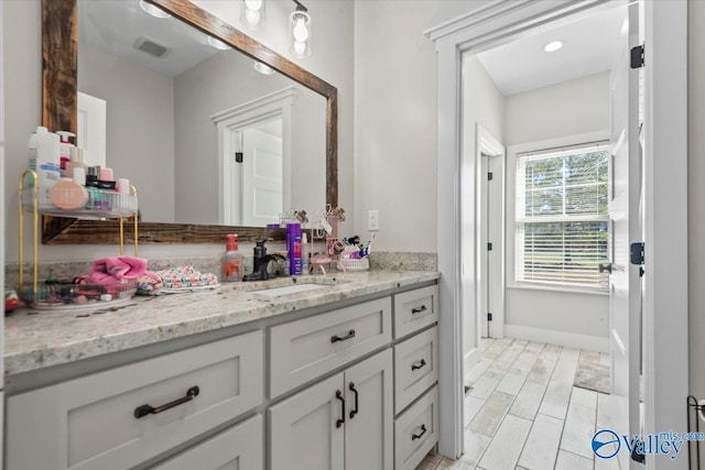 bathroom with baseboards, visible vents, and vanity