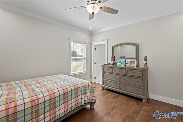 bedroom with dark wood-style floors, crown molding, baseboards, and ceiling fan