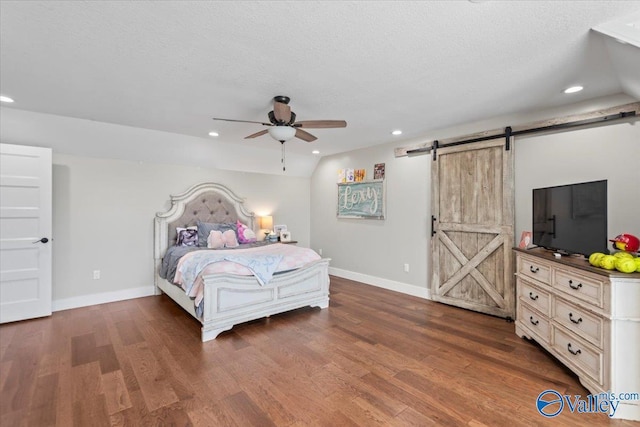 bedroom featuring recessed lighting, dark wood finished floors, baseboards, and a barn door