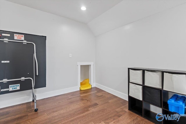 interior space with lofted ceiling, baseboards, wood finished floors, and recessed lighting