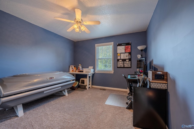 office with a textured ceiling, carpet flooring, and ceiling fan