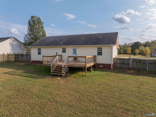 back of property with a wooden deck and a yard