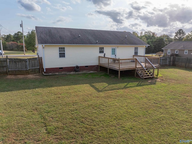 back of property with a deck and a lawn