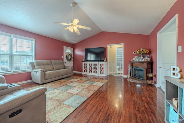 living room with ceiling fan, hardwood / wood-style flooring, and vaulted ceiling