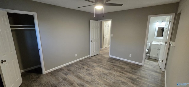unfurnished bedroom with ensuite bath, ceiling fan, sink, dark hardwood / wood-style flooring, and a closet