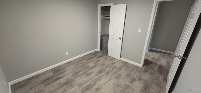 unfurnished bedroom featuring wood-type flooring and a closet
