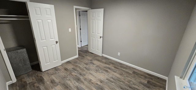 unfurnished bedroom with dark hardwood / wood-style flooring and a closet