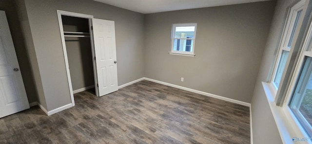 unfurnished bedroom with a closet and dark wood-type flooring