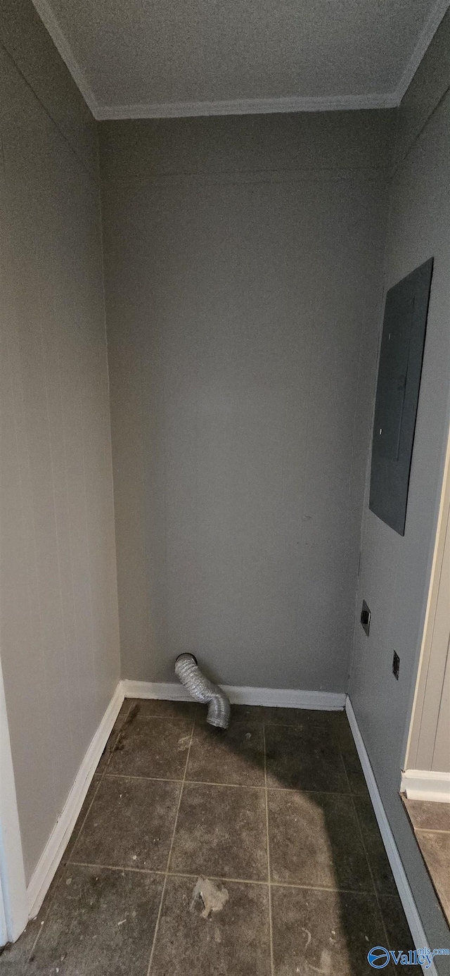 washroom featuring hookup for an electric dryer, crown molding, electric panel, and dark tile patterned flooring
