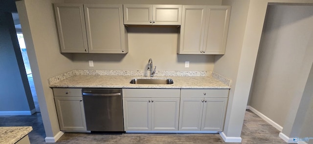 kitchen featuring gray cabinets, light stone countertops, sink, and stainless steel dishwasher